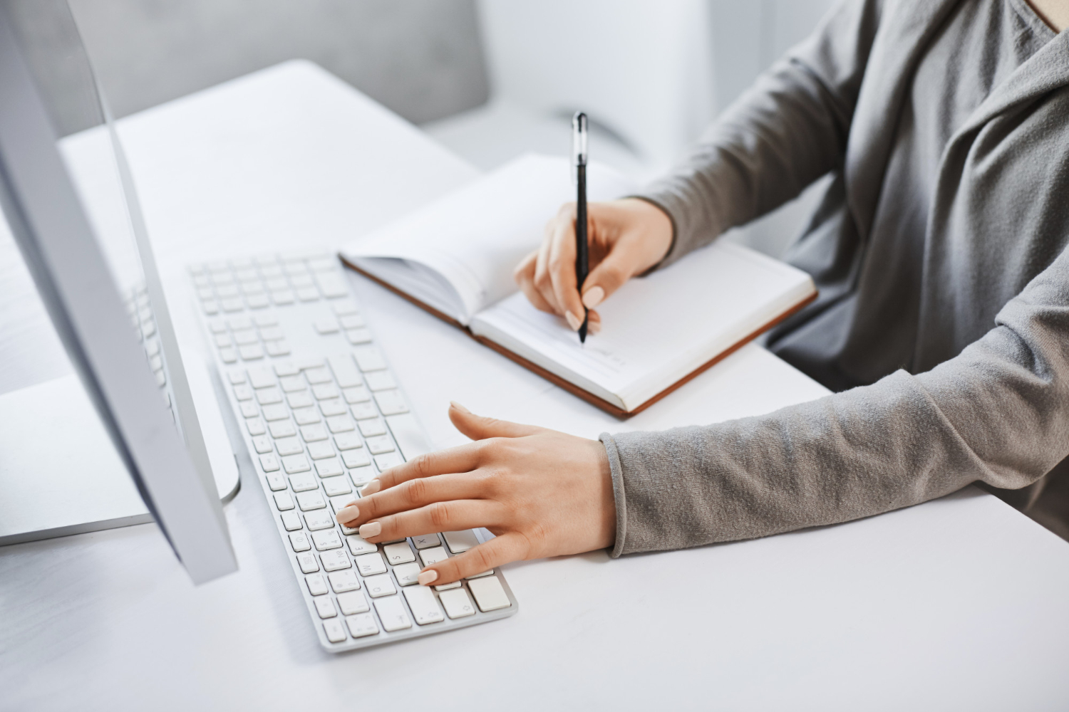 Girl is typing a keyboard and making notes