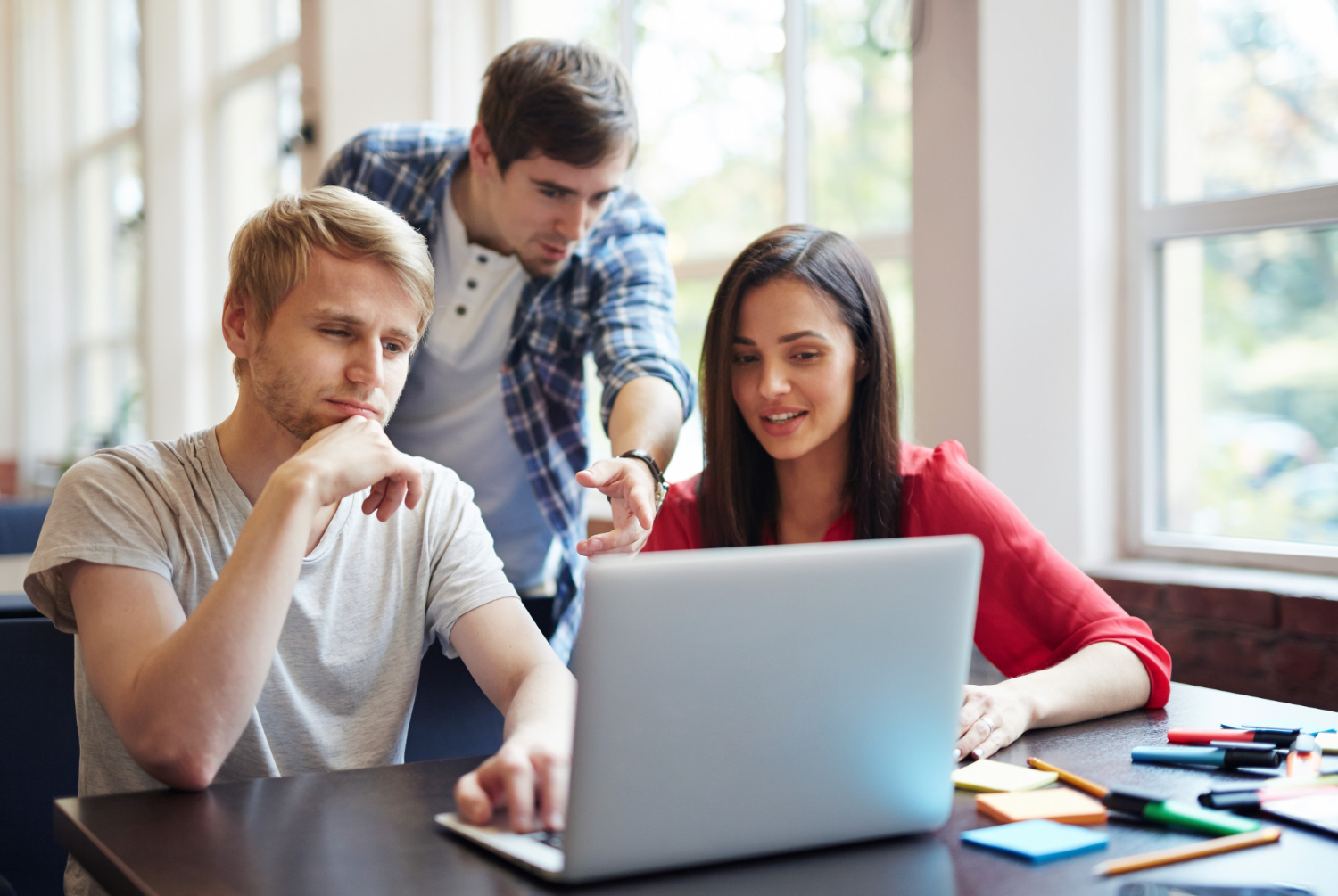 Students with laptop are discussing something